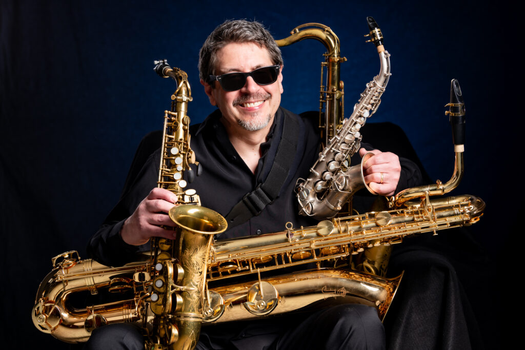saxophone player with 4 horns around him